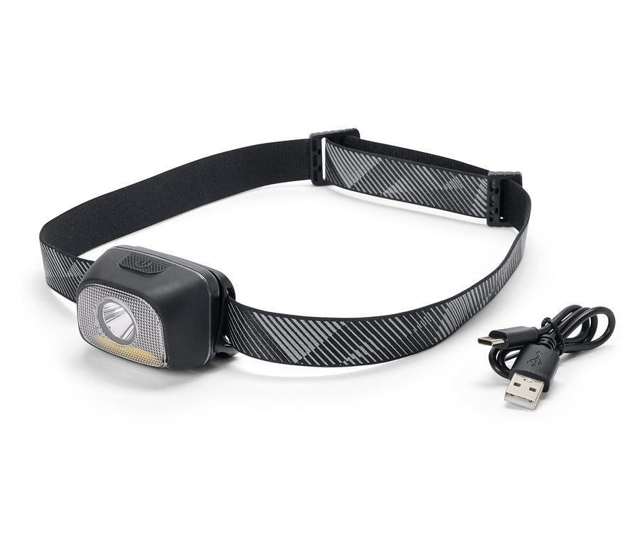 Eine schwarze Stirnlampe mit einem grau-weiß gemusterten Band und einem USB-Ladekabel.