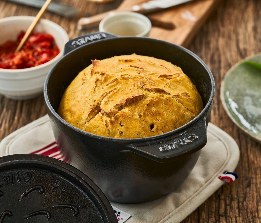 Brotlaib in schwarzer 16 cm Staub Reis-Cocotte auf einem Holztisch.