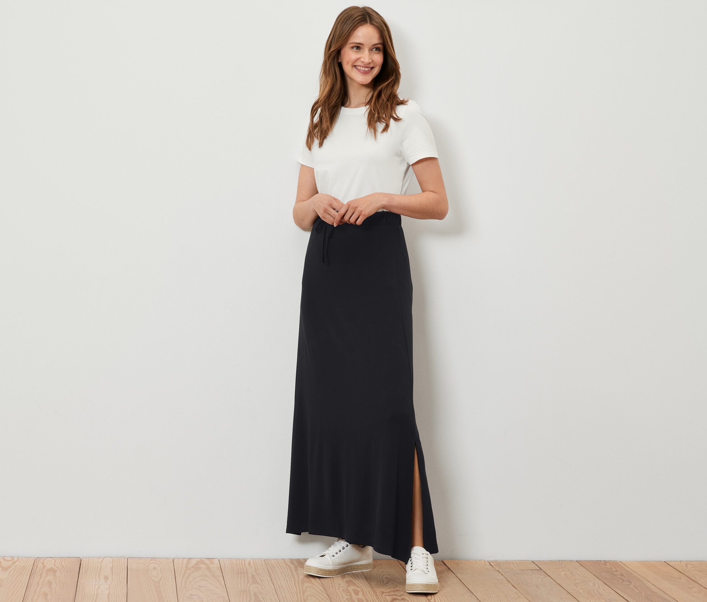 Frau posiert in langem schwarzen Jerseyrock.