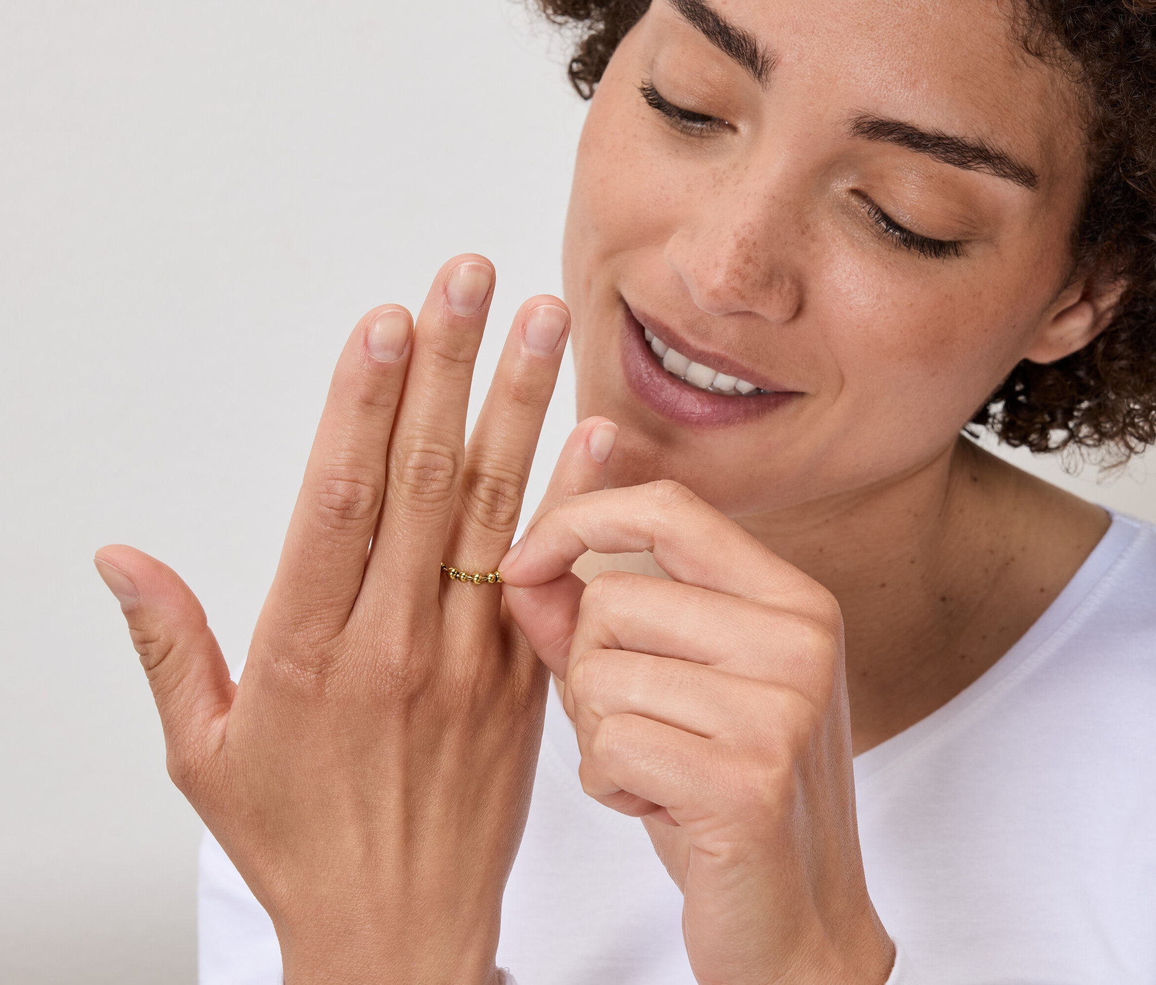 Frau betrachtet goldenen Ring am Finger.