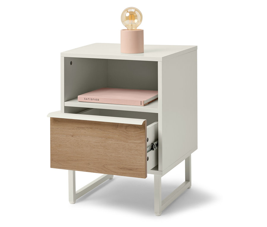 Weißer Nachttisch mit Holzschublade und rosa Lampe.