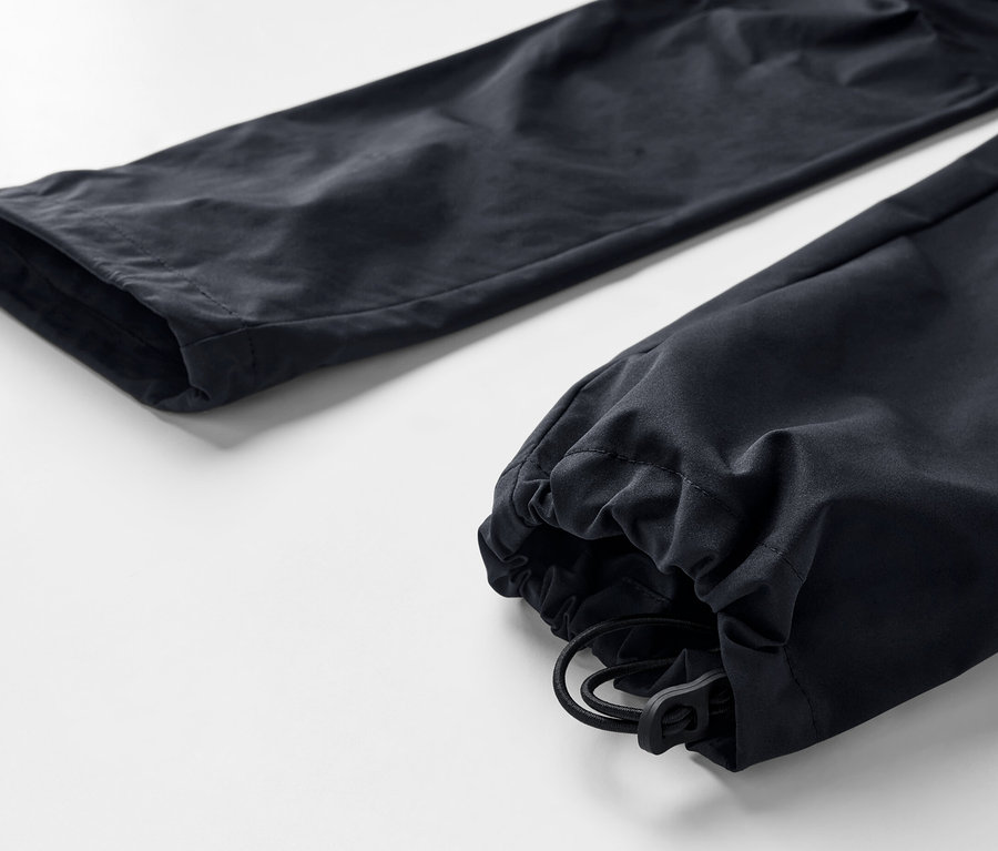 Detailaufnahme einer schwarzen 2-in-1-Funktionshose mit Kordelzug am Beinabschluss.