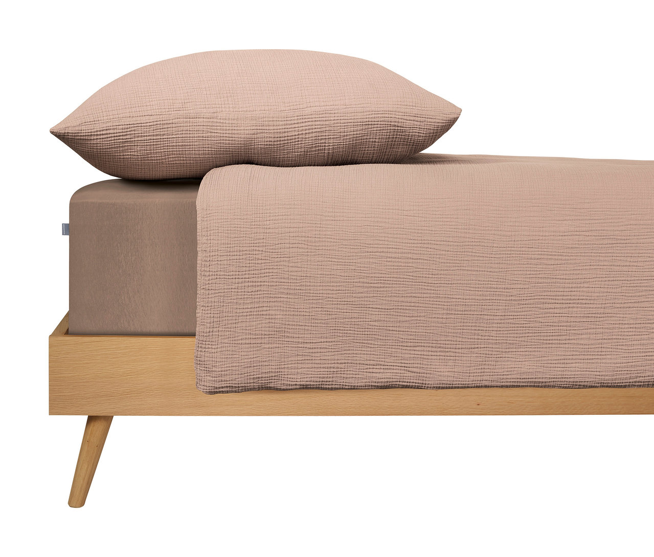 Bett mit hellbraunem Laken und Kissen auf einem Holzrahmen.