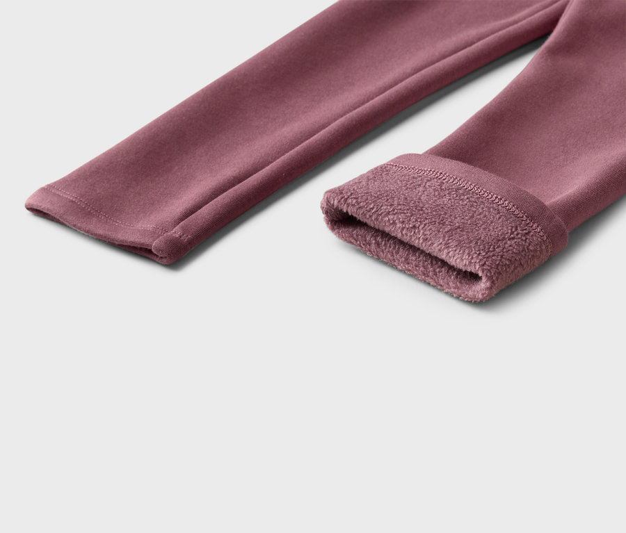 Nahaufnahme einer weinroten Leggings mit Fleece-Futter am Beinabschluss.