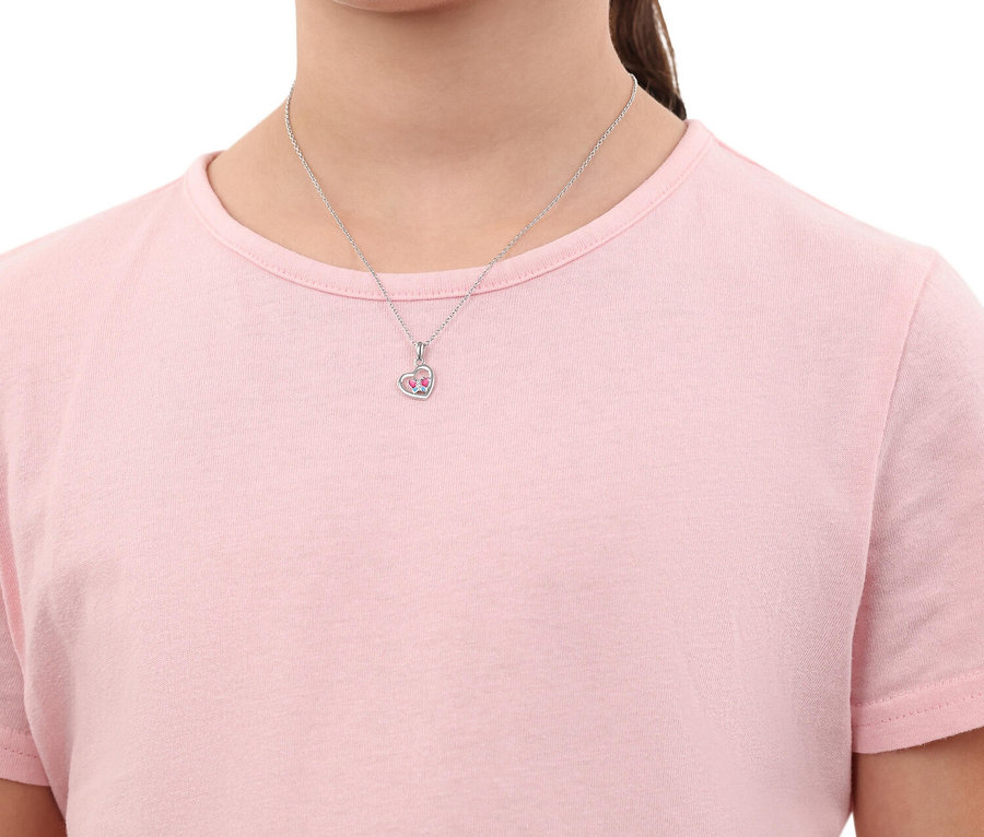 Eine junge Person trägt eine silberne Halskette mit einem herzförmigen Anhänger, der mit rosa Steinen besetzt ist.