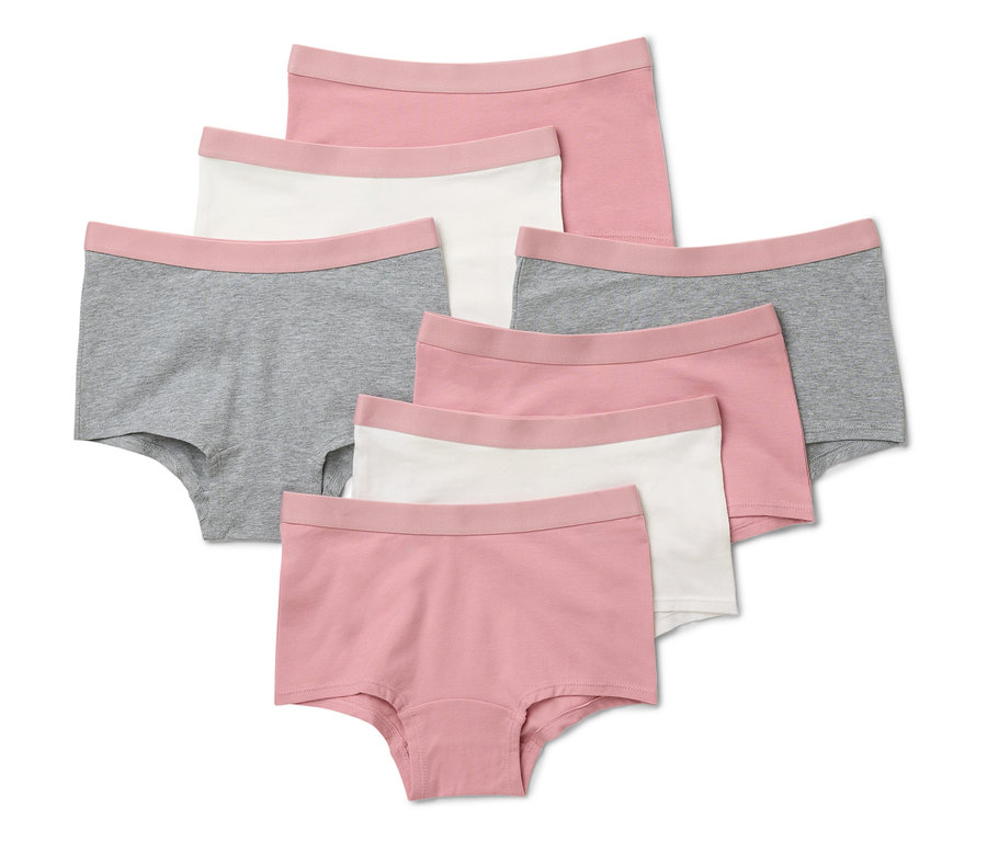 Sieben altrosa Mädchen Pantys liegen auf einem weißen Hintergrund.