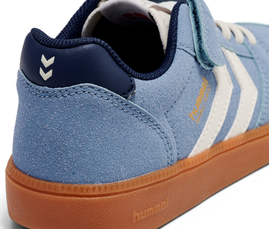 Nahaufnahme eines hellblauen Hummel-Sneakers mit brauner Sohle und Klettverschluss.
