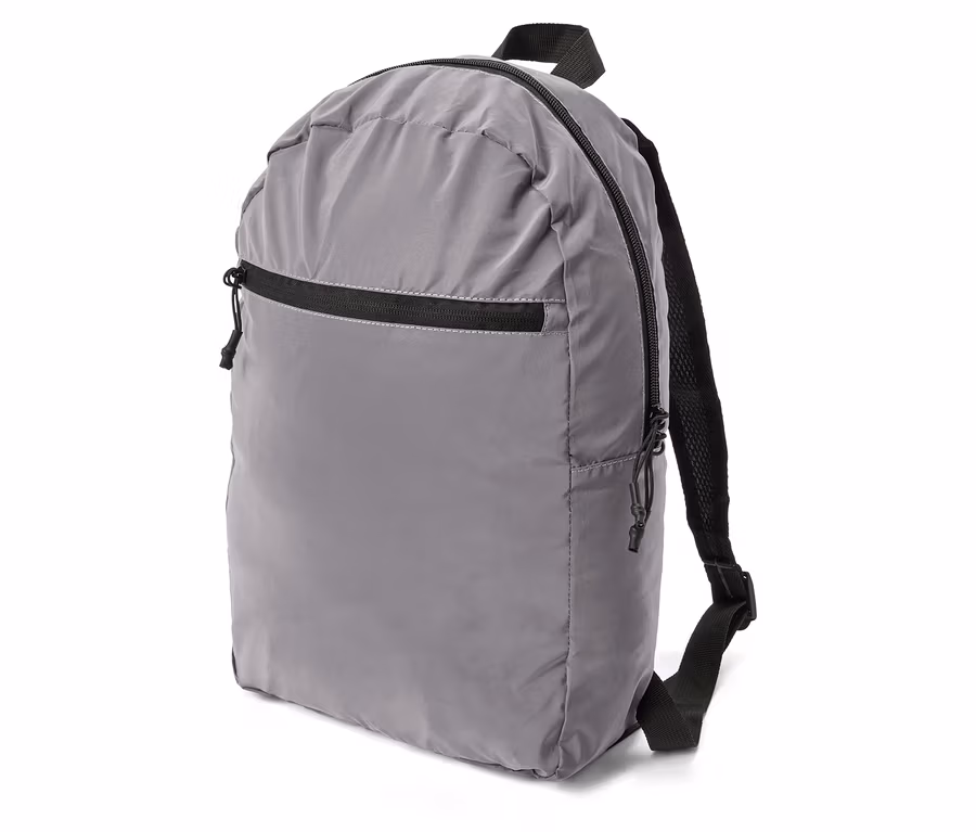 Grauer Rucksack mit schwarzem Reißverschluss und Trägern, seitlich auf weißem Grund.