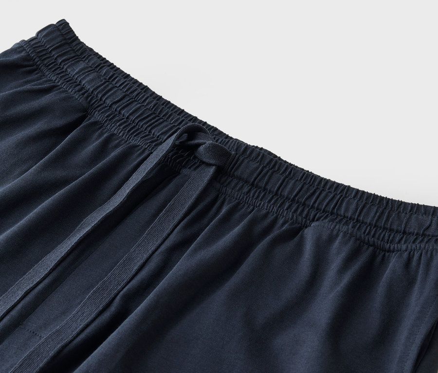 Nahaufnahme von dunkelblauen Stoffhosen mit Kordelzug.