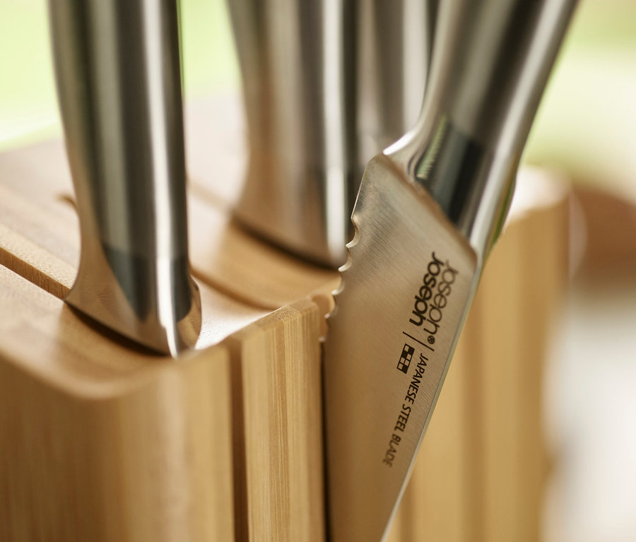 Nahaufnahme von Messern aus japanischem Stahl mit Holzgriffen in einem Messerblock.