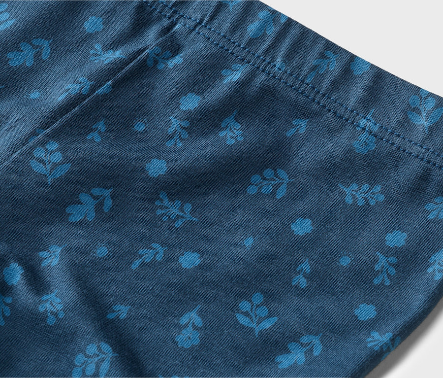 Nahaufnahme einer marineblauen Leggings mit hellblauen Blumen- und Blattmustern und einem elastischen Bund.