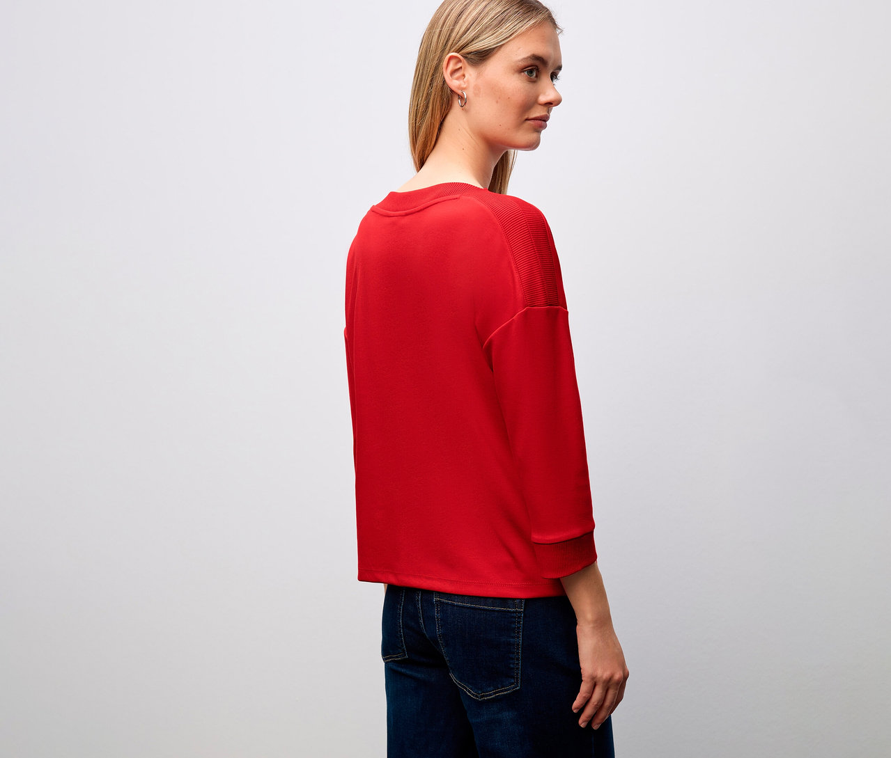 Frau trägt ein rotes Street One T-Shirt mit Rippdetail und Jeans.