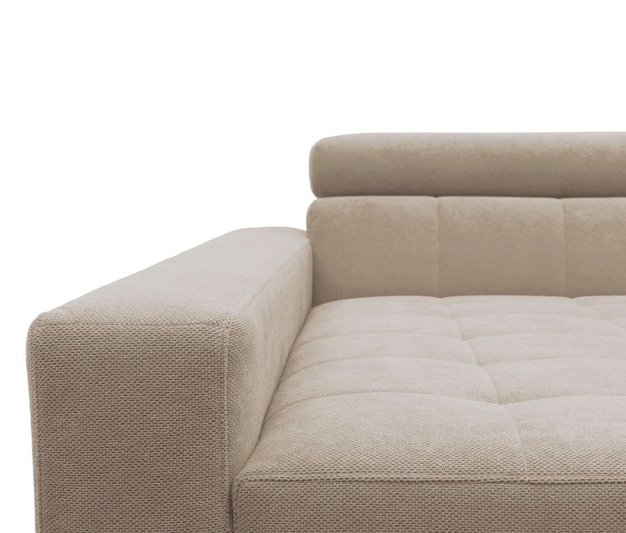 Nahaufnahme eines beigen Sofas mit Armlehne, Sitzfläche und Rückenlehne. Die Armlehne und der Sockel sind mit einem strukturierten, gewebten Stoff bezogen, während die Sitz- und Rückenpolster aus einem weicheren, gesteppten Material bestehen. Die Rückenlehne verfügt über eine verstellbare Kopfstütze.