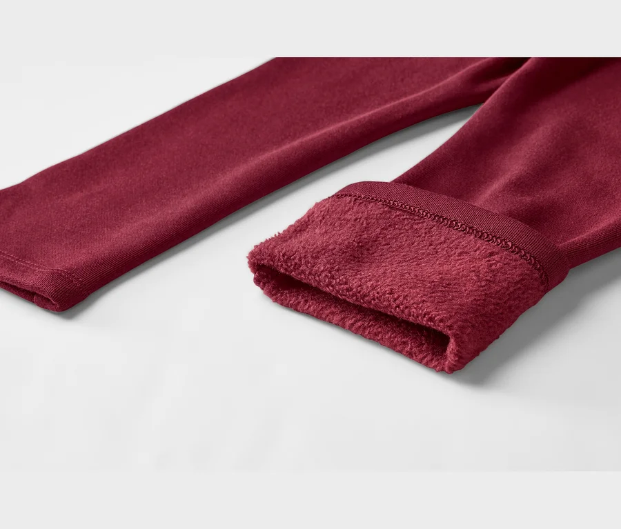 Nahaufnahme eines bordeauxroten Kleidungsstücks, das den glatten Oberstoff und ein weiches, flauschiges Fleecefutter am Ärmelbund zeigt.