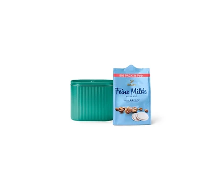 Eine Dose und eine Packung Tchibo Feine Milde Kaffeepads stehen nebeneinander.