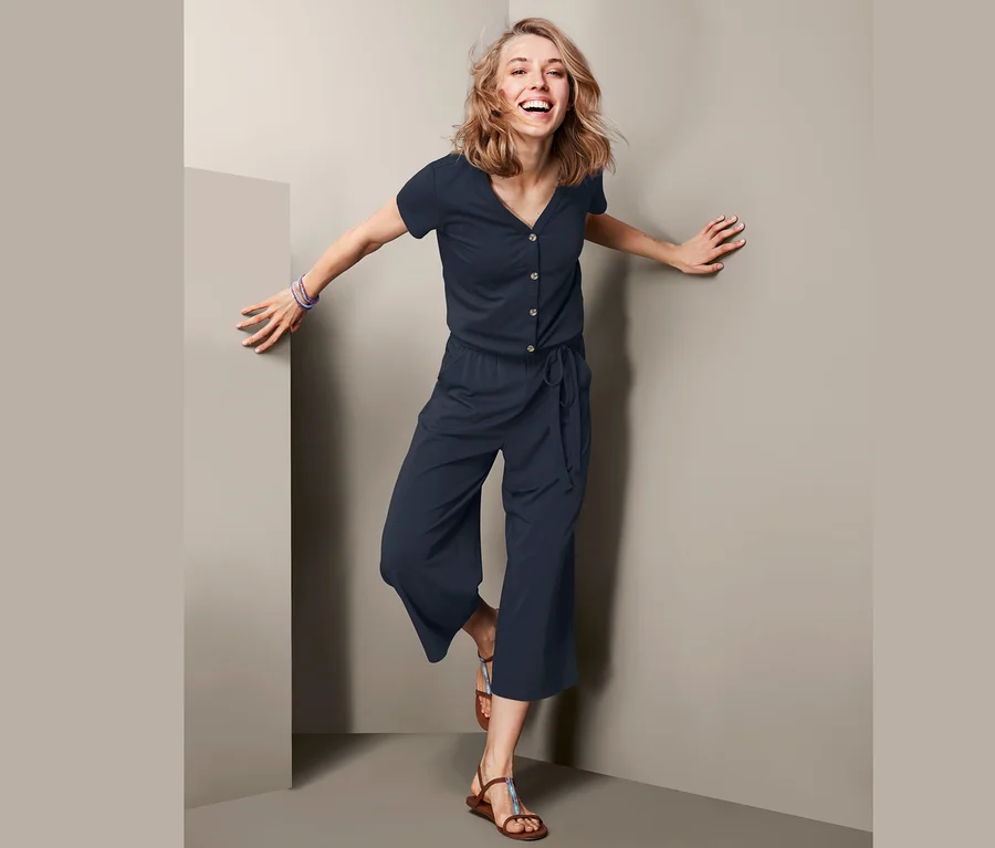 Frau posiert in marineblauem Jumpsuit.