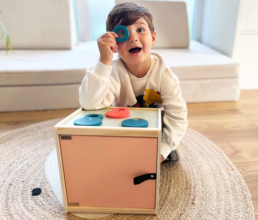 Junge schaut durch blaue Form aus small foot Sinnes-und-Fühl-Box »Sensory«.