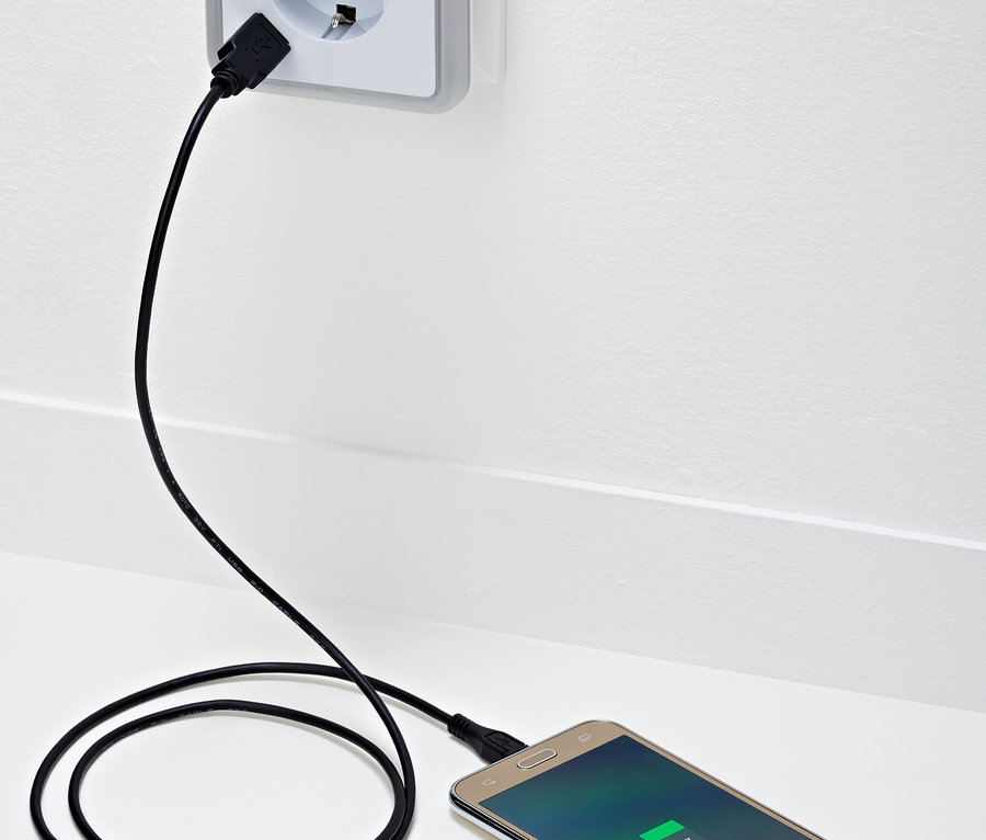 Handy wird über LED-Nachtlicht mit Steckdose und USB-Lademöglichkeit aufgeladen.