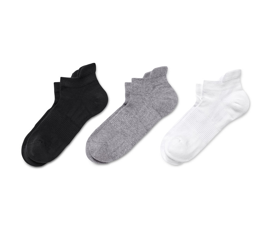 Schwarze, graue und weiße 3 Paar Sport-Sneakersocken liegen nebeneinander.