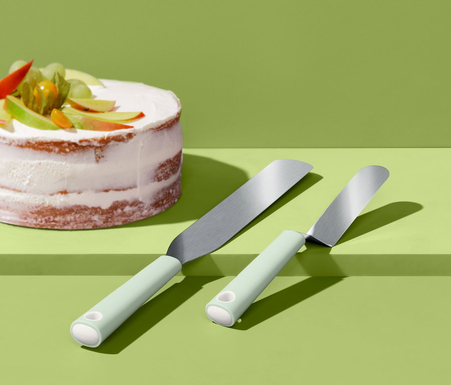 Zwei Streichpaletten liegen neben einem Kuchen mit Früchten.