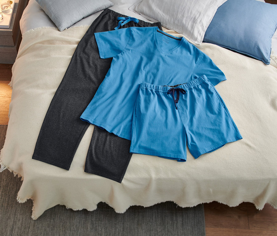 Auf einem Bett liegt ein 3-teiliges Pyjama-Set.