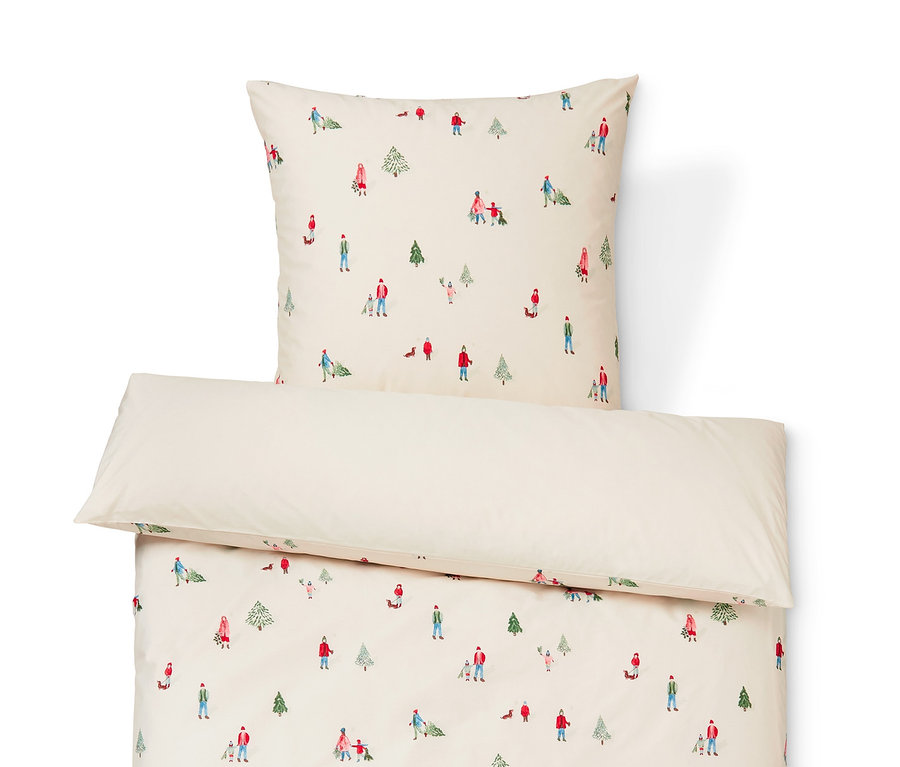 Eine Premium-Baumwoll-Bettwäsche mit Weihnachtsmotiv. Auf der Bettwäsche sind Menschen und Bäume abgebildet.