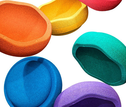 Sechs farbige Stapelstein Original »rainbow classic« liegen auf einem weißen Hintergrund.