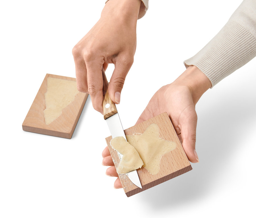 Hände verteilen Teig auf 2 Spekulatiusformen aus Holz.