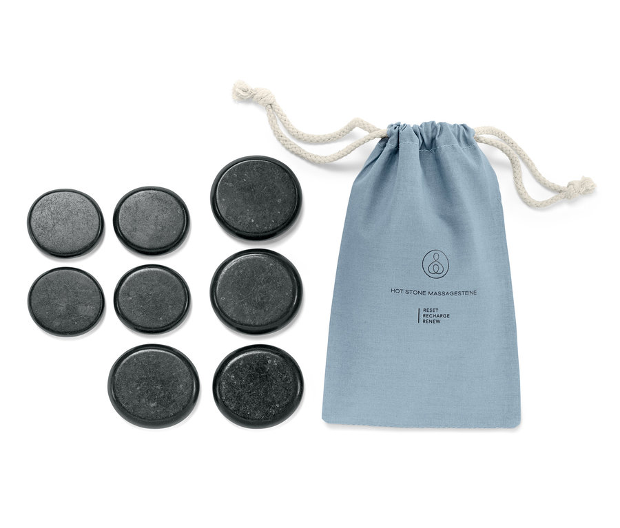 Ein Hot Stones Massageset und eine blaue Stofftasche mit Kordelzug liegen auf einem weißen Hintergrund.