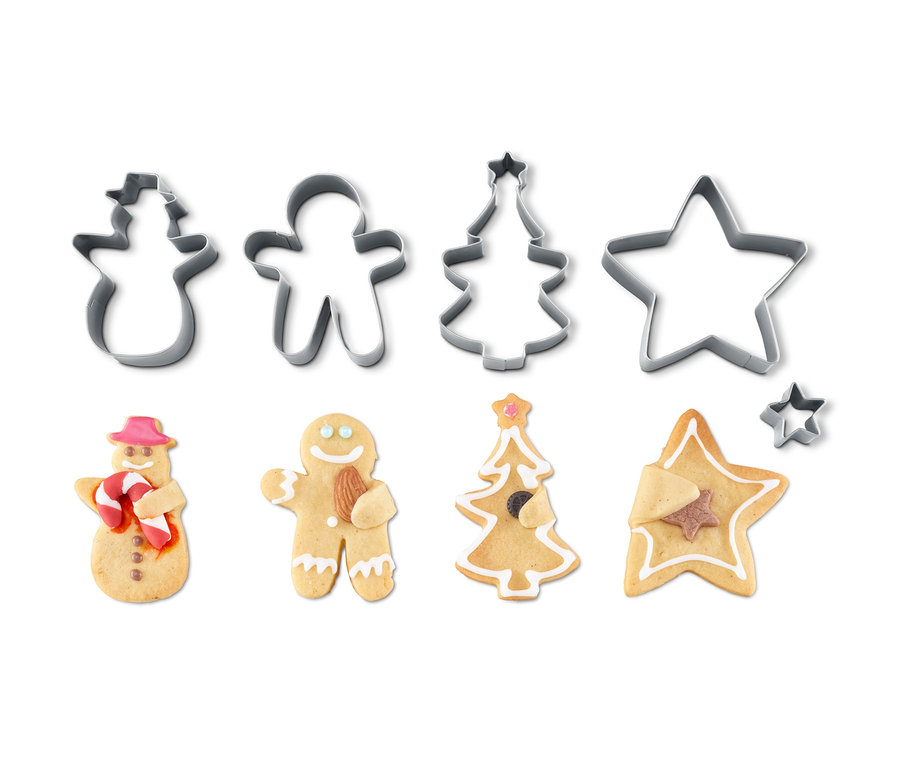 Kuschelkeks-Ausstecher in Form von Schneemann, Lebkuchenmann, Weihnachtsbaum und Stern mit gebackenen Keksen in der gleichen Form.