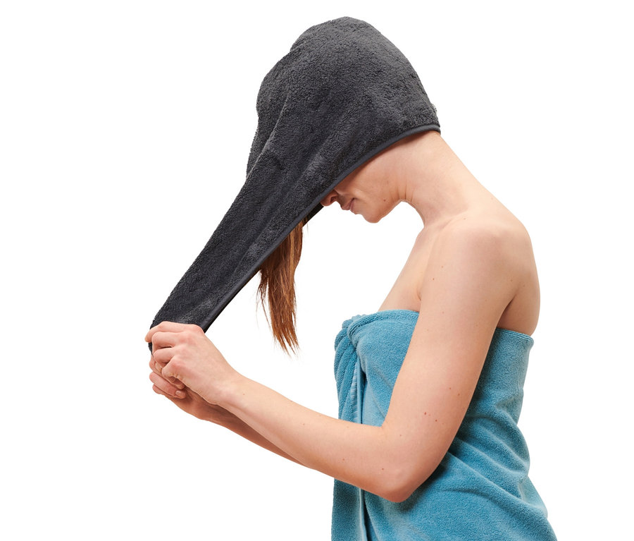 Frau setzt Turban-Handtuch, anthrazitfarben, auf den Kopf.