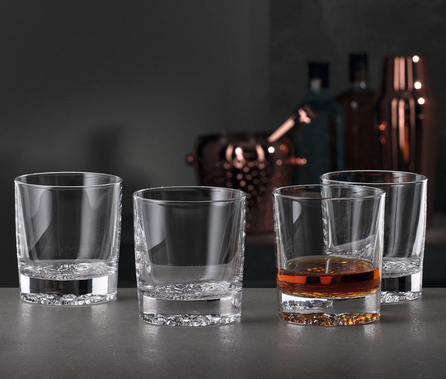 Vier Spiegelau Single-Old-Fashioned-Gläser »Lounge 2.0«, eines mit brauner Flüssigkeit gefüllt.