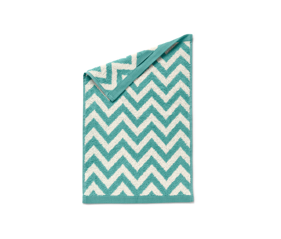 Ein gefaltetes Gästehandtuch mit Zickzackmuster in Türkis und Weiß.