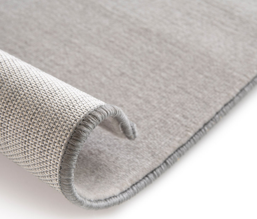 Detailansicht des Kinderteppichs COCOON »Herz«, 120 x 170 cm, der an der Kante aufgerollt ist.