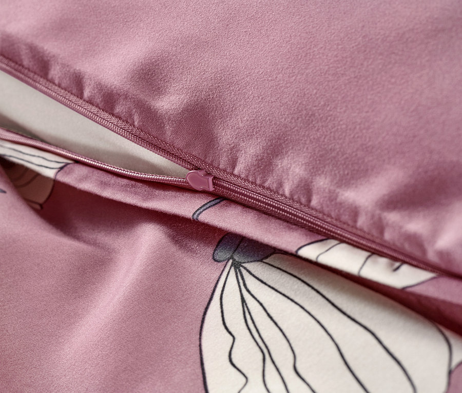 Detailaufnahme von altrosa Microfaser-Bettwäsche mit Reißverschluss und Blumenmuster.