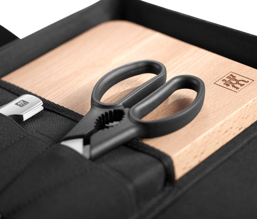Messer, Schere und Schneidebrett im ZWILLING Messer-Traveller-Set in einer schwarzen Tasche.