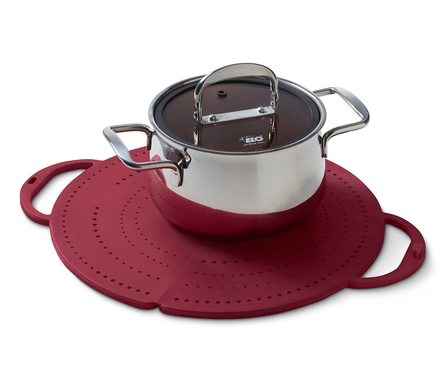 Ein Edelstahltopf mit Deckel steht auf einem roten 4-in-1-Pfannenspritzschutz.