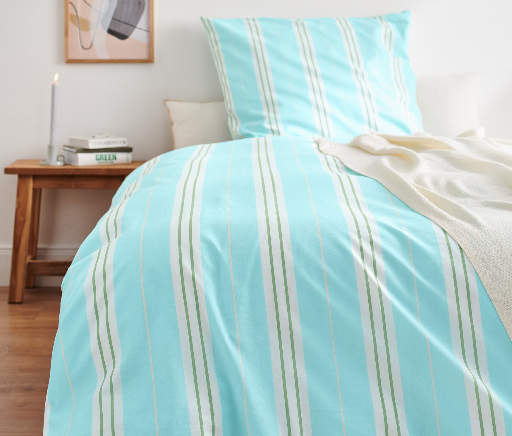 Blau gestreifte Premium-Baumwoll-Bettwäsche in Normal-, Doppel- und Übergröße auf einem Bett.