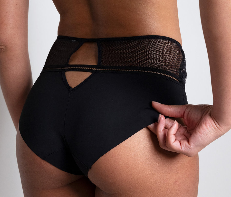 Frau posiert in schwarzem Höschen und BH. Im Fokus: Passionata Taillenslip »Olivia«.