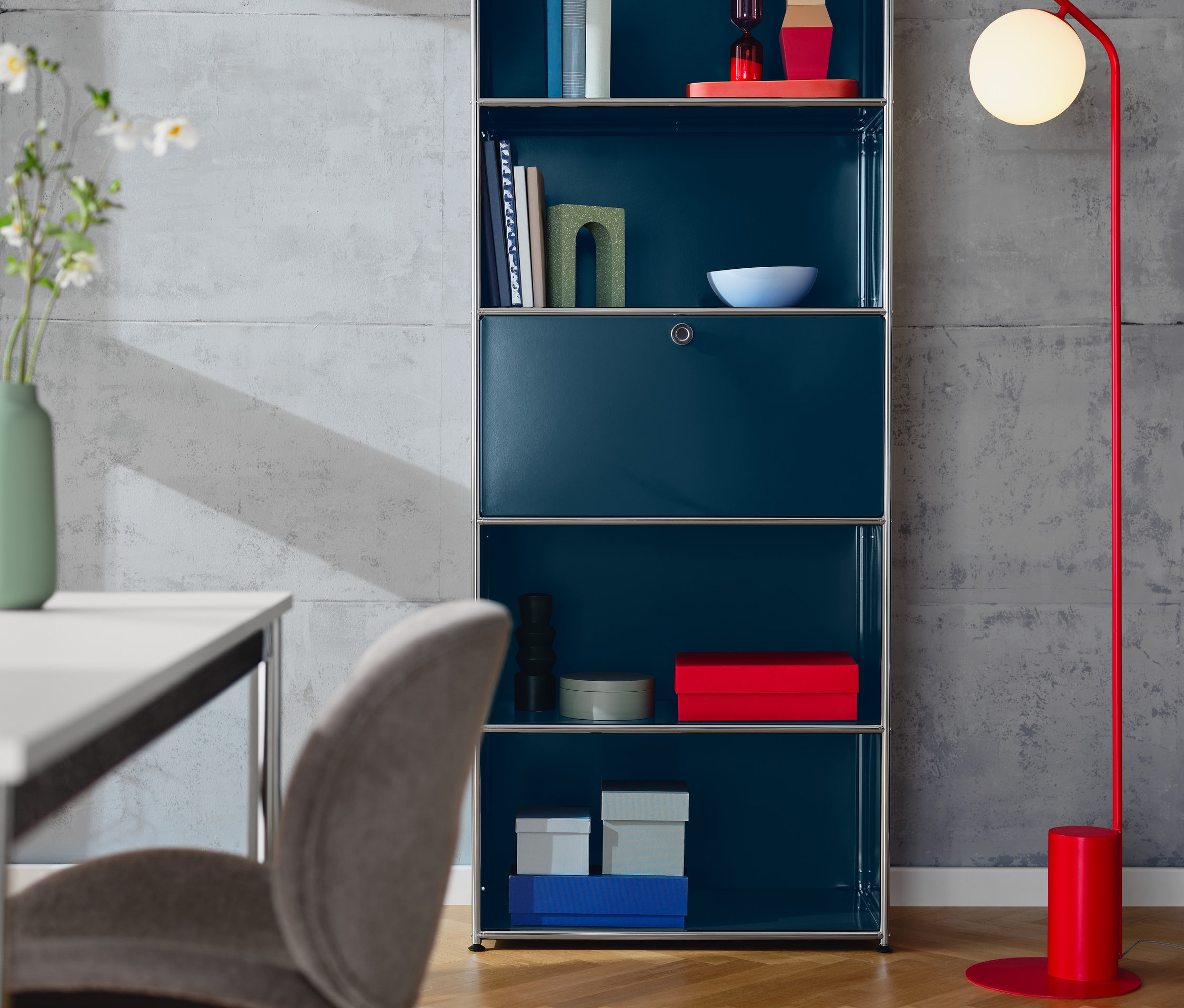 Blaues hohes Regal »CN3« mit Klappenfach und ein gepolsterter Designstuhl in Greige.