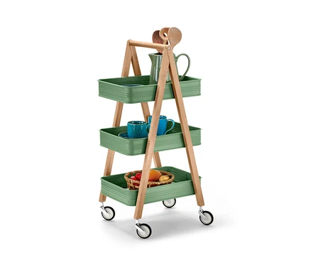 Ein dreistöckiger Küchen-Servierwagen mit grünen Ablagen und Holzrahmen. Auf den Ablagen befinden sich Früchte, Tassen und ein Krug.