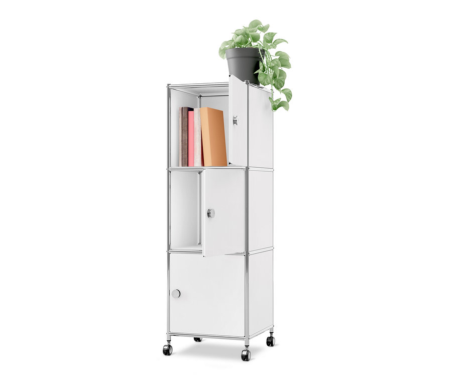 Weißer Metall-Rollcontainer »CN3« mit drei Türen und Rollen. Im oberen offenen Fach stehen drei Bücher. Eine obere und eine mittlere Tür sind leicht geöffnet, die untere Tür ist geschlossen. Oben auf dem Container steht eine grüne Topfpflanze.