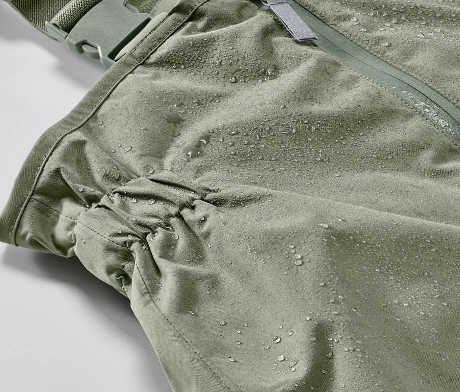 Detailaufnahme einer Kleinkind-Regenhose mit Wassertropfen.