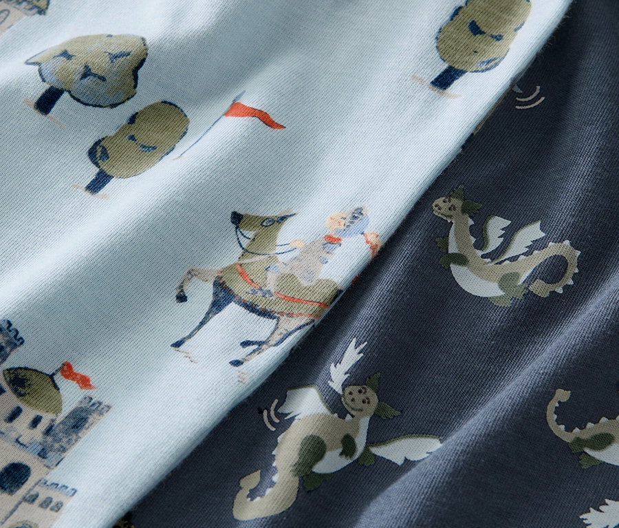 Nahaufnahme von blauen Kinder-Pyjamas mit Ritter auf Pferd und Burg Muster.