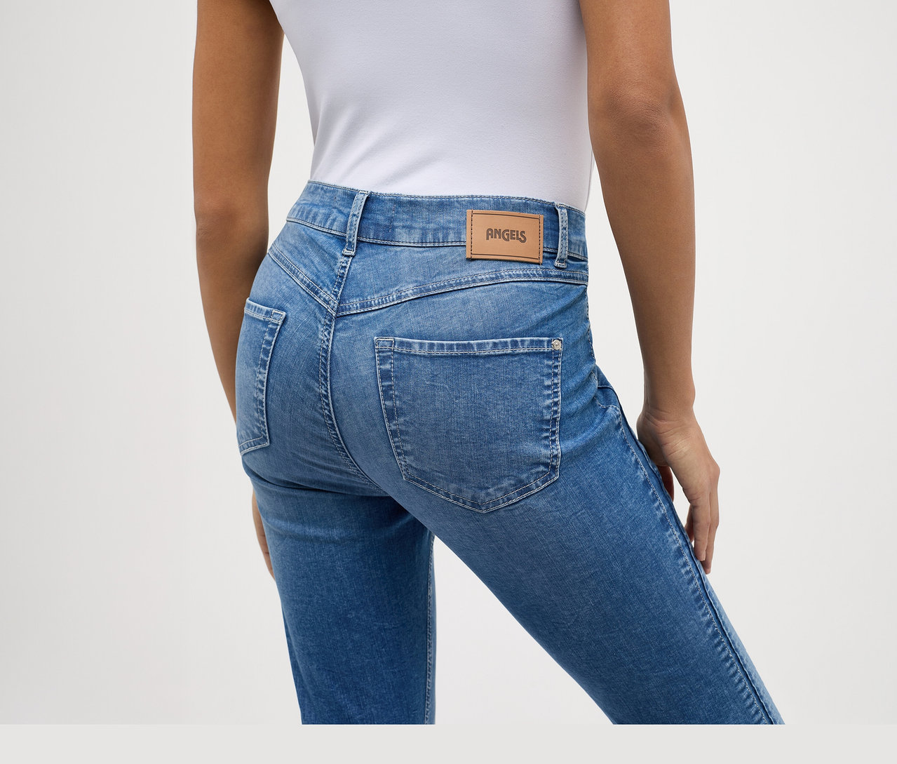 Rückenansicht einer Person in hellblauen Angels Jeans »Ornella Seam« Slim Fit 7/8 und einem weißen Oberteil.