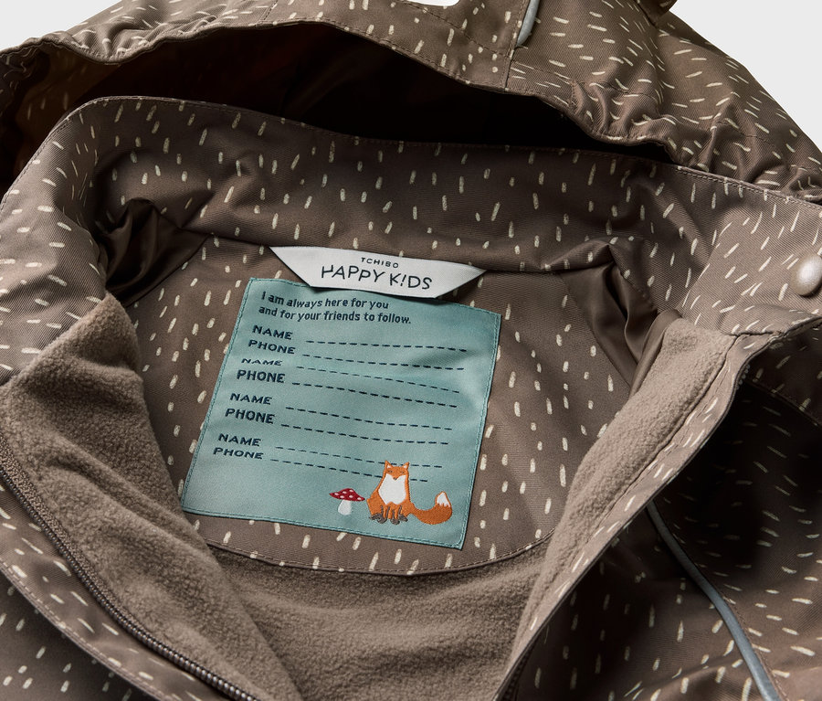 Detailansicht einer Kinder-Thermo-Regenjacke mit Bärenkapuze und Innenetikett.