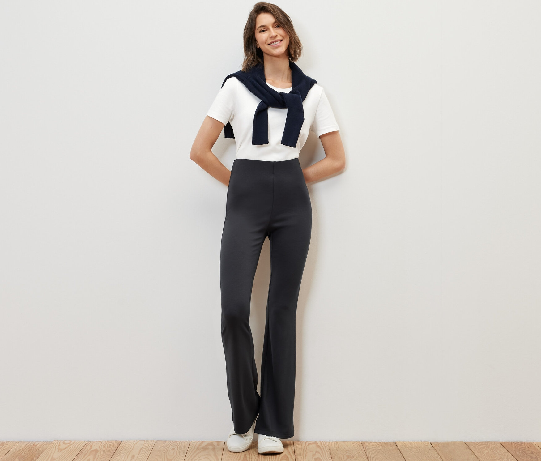 Frau posiert stehend in ausgestellten Leggings.