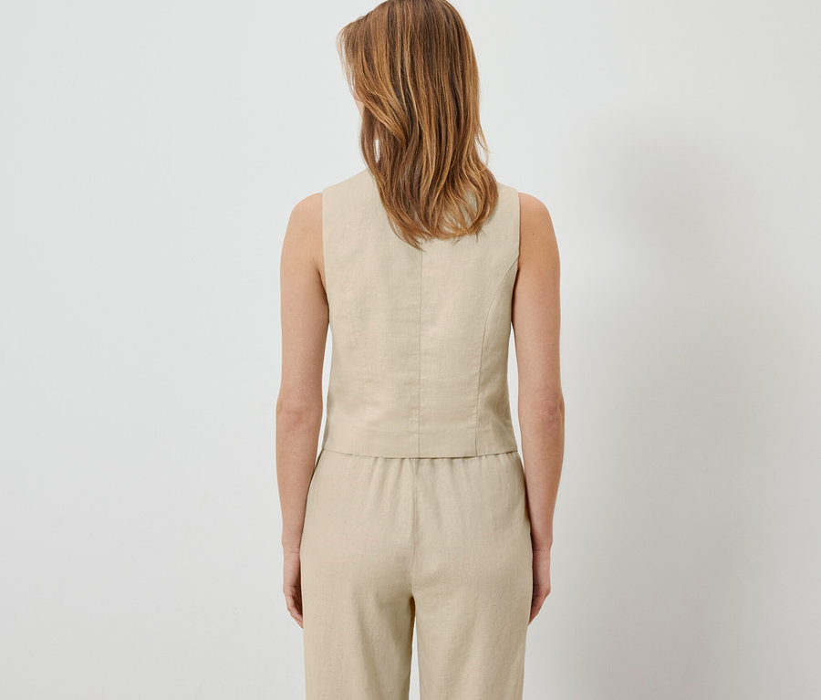 Rückansicht einer Frau, die eine Leinen-Weste und Hose trägt.