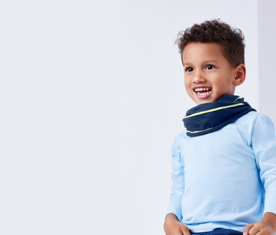 Ein Junge mit einem Multifunktionstuch um den Hals.