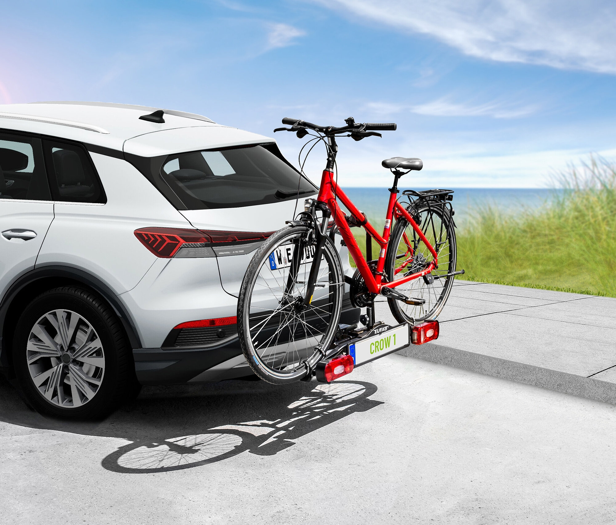 Rotes Fahrrad montiert auf EAL Fahrradträger »CROW 1« auf der Rückseite eines weißen Autos.